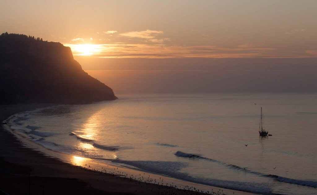 View of the beach at Hotel do Mar at sunset