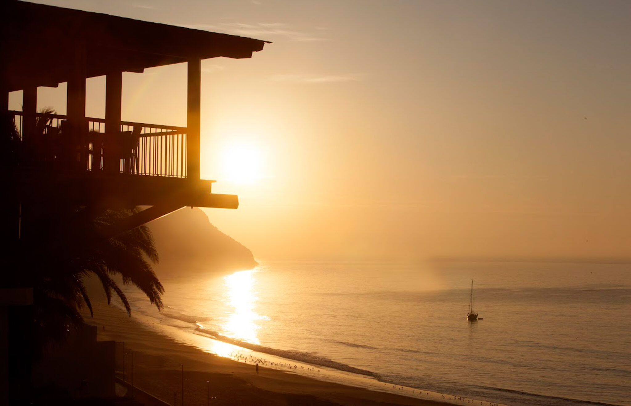 View of the beach at Hotel do Mar at sunset