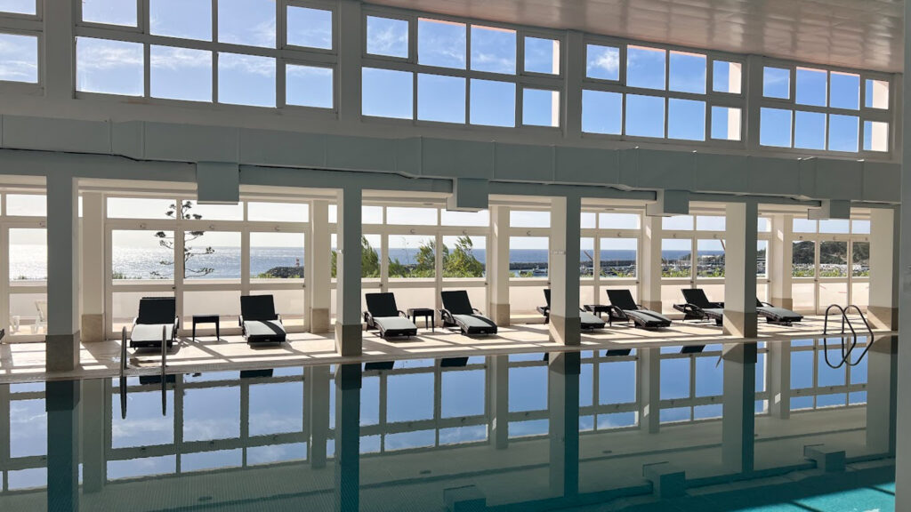 Indoor pool with loungers at Hotel do Mar