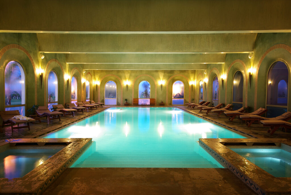 Indoor pool at Hotel du Golf Rotana with loungers