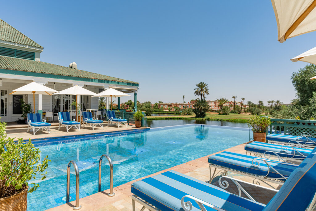 Outdoor pool with loungers at Hotel du Golf Rotana