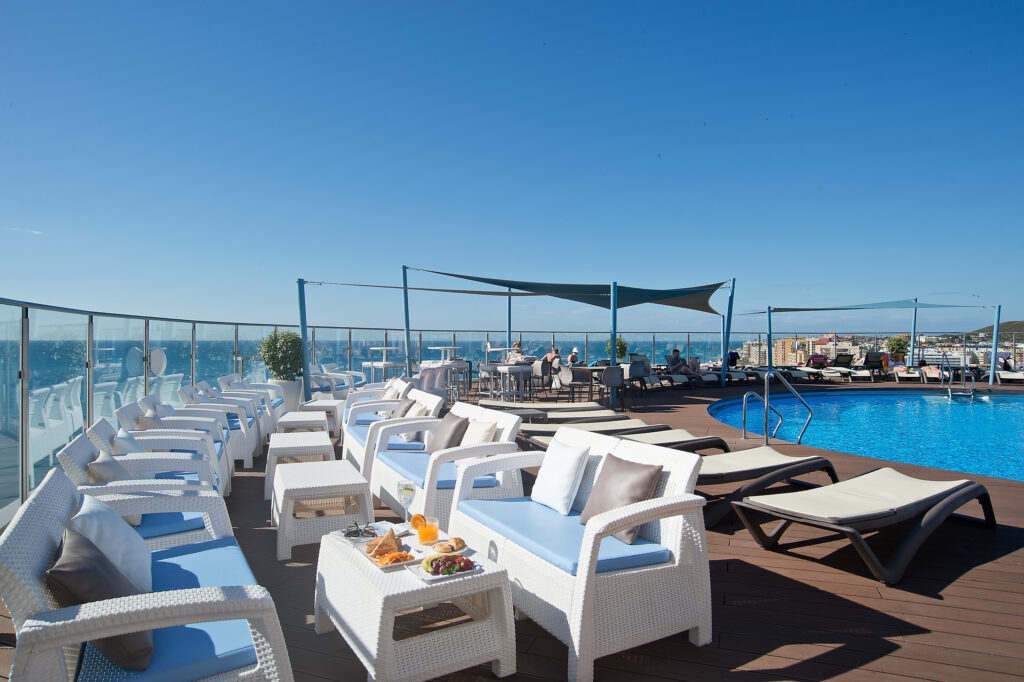 Seating around outdoor pool at Hotel El Puerto