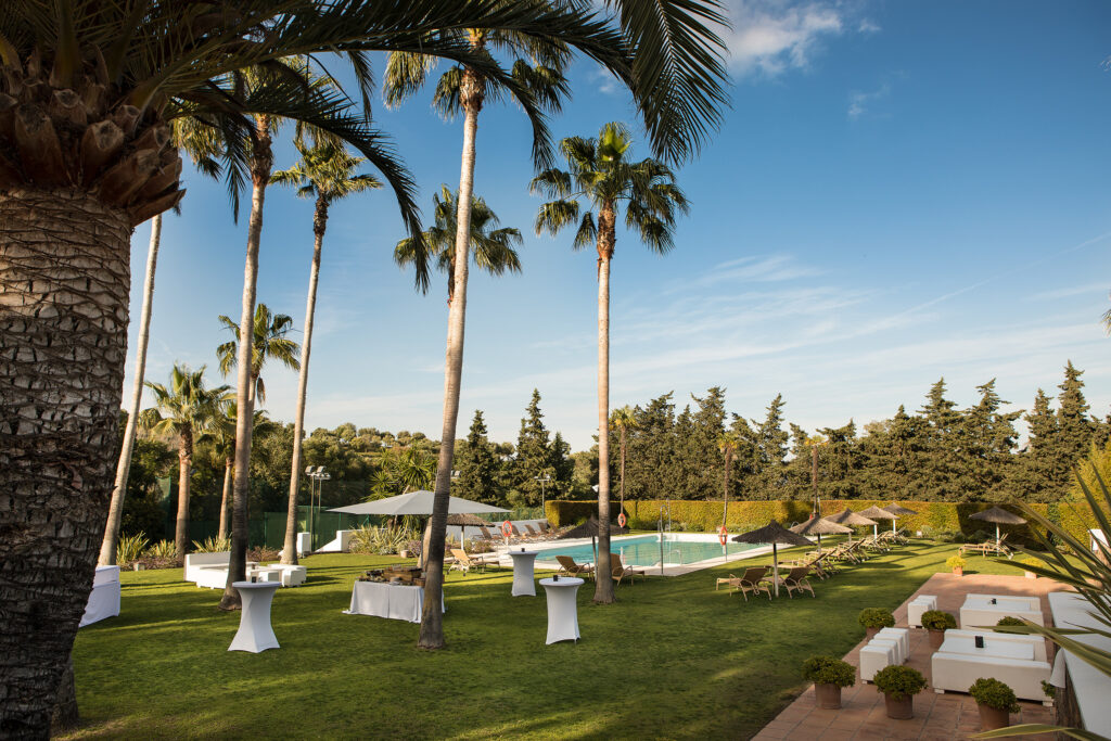 Outdoor pool with palm trees at Hotel Encinar de Sotogrande