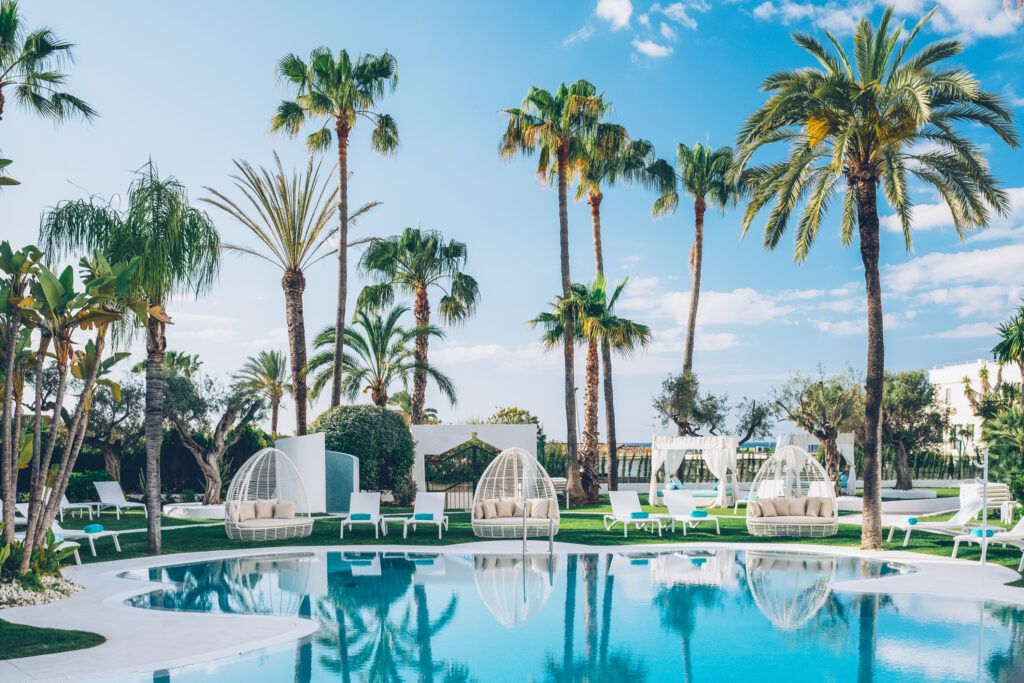 Outdoor pool with palm trees at Iberostar Selection Marbella Coral Beach