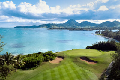 Hole with bunkers at Ile Aux Cerfs Golf Club with ocean view and hills in background