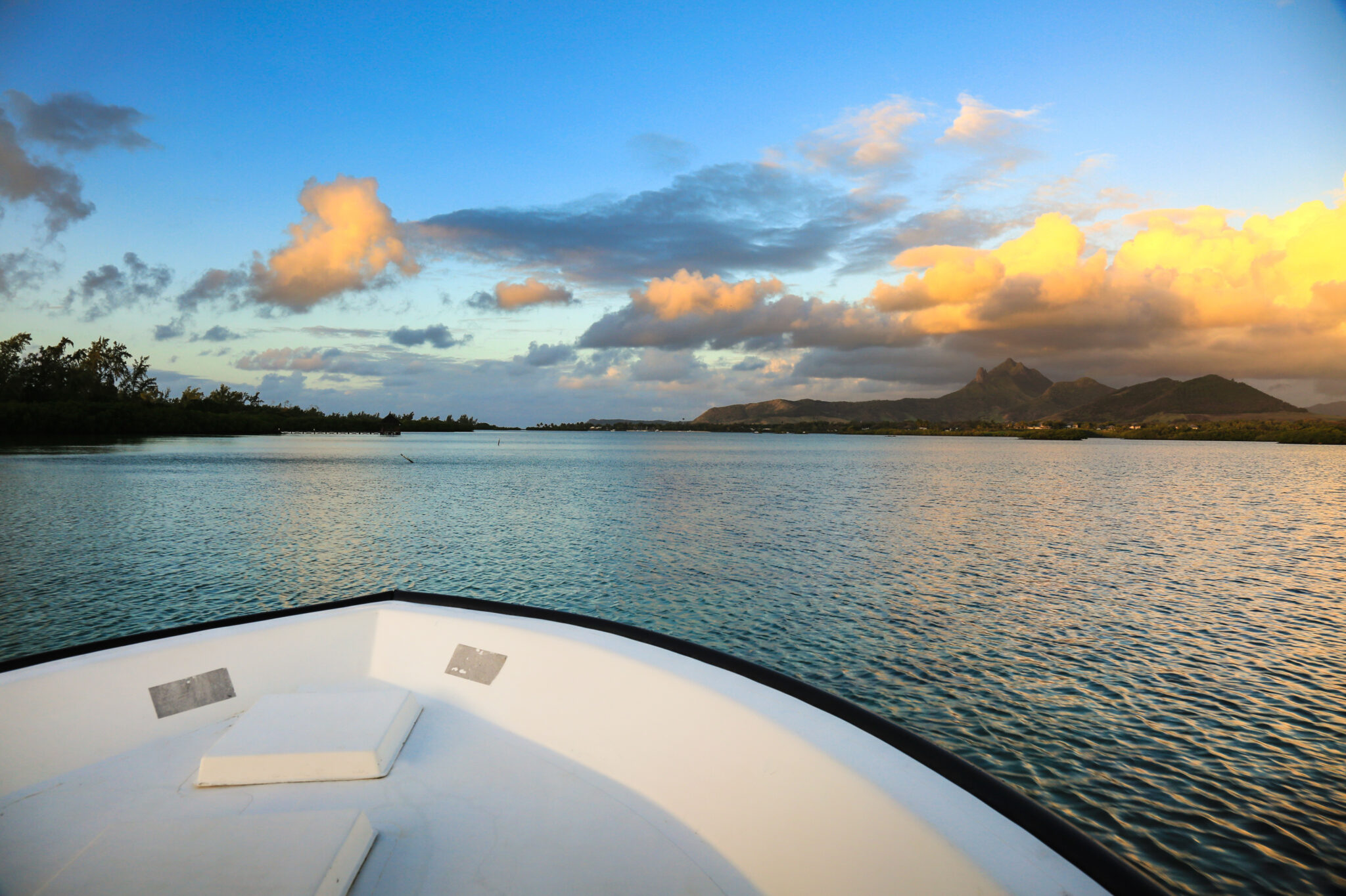 View of ocean from a boat at Ile Aux Cerfs Golf Club with hills in distance