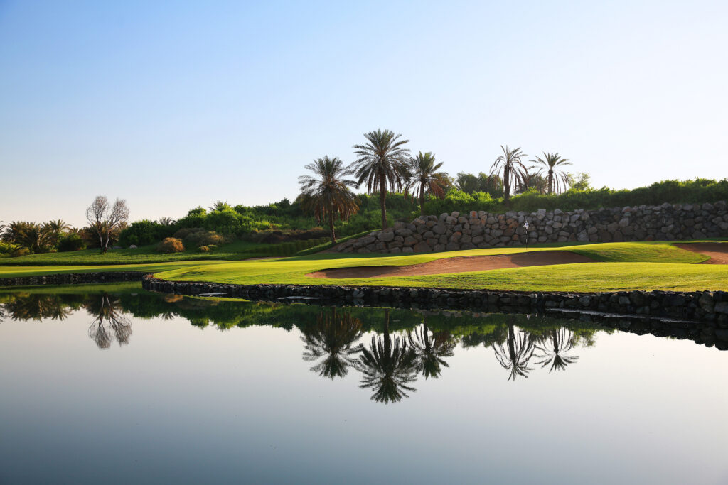 Fairway with bunkers and lake next to it at Abu Dhabi Golf Club - National