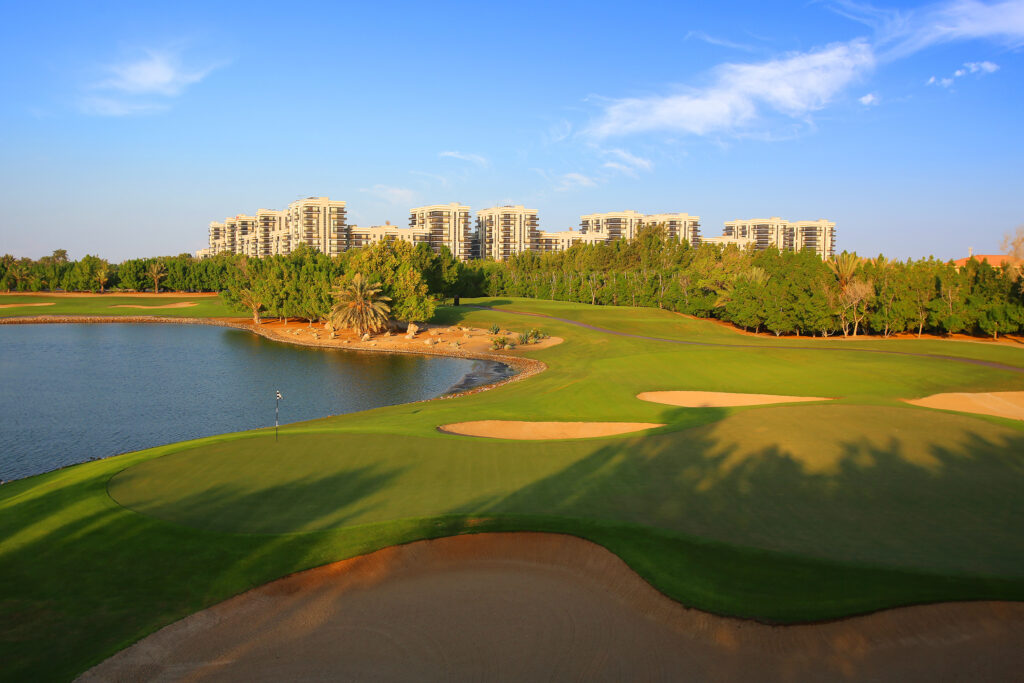 Hole with bunkers at Abu Dhabi Golf Club - National with a lake next to it