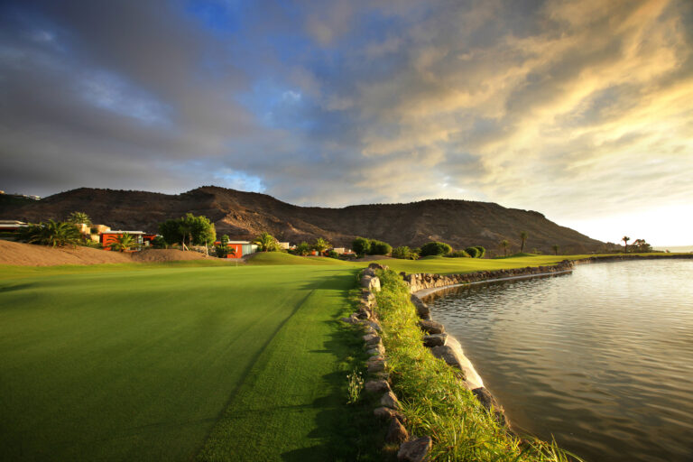 Fairway with lake and hills in distance at Anfi Tauro