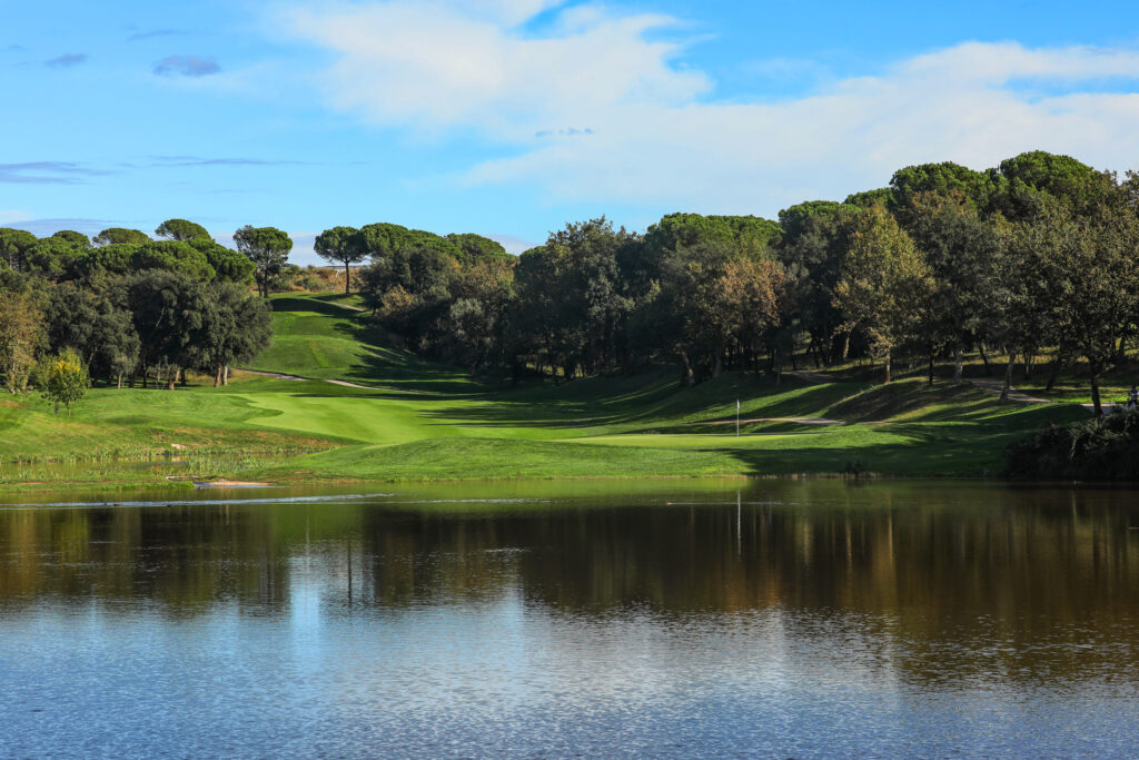 Fairway with a lake and trees around at Camiral Golf & Wellness - Stadium Course