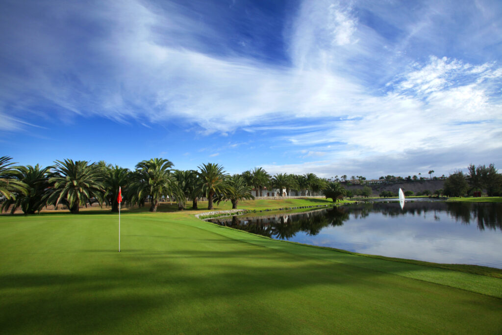 Hole with lake atCampo de Golf de Maspalomas with trees in background