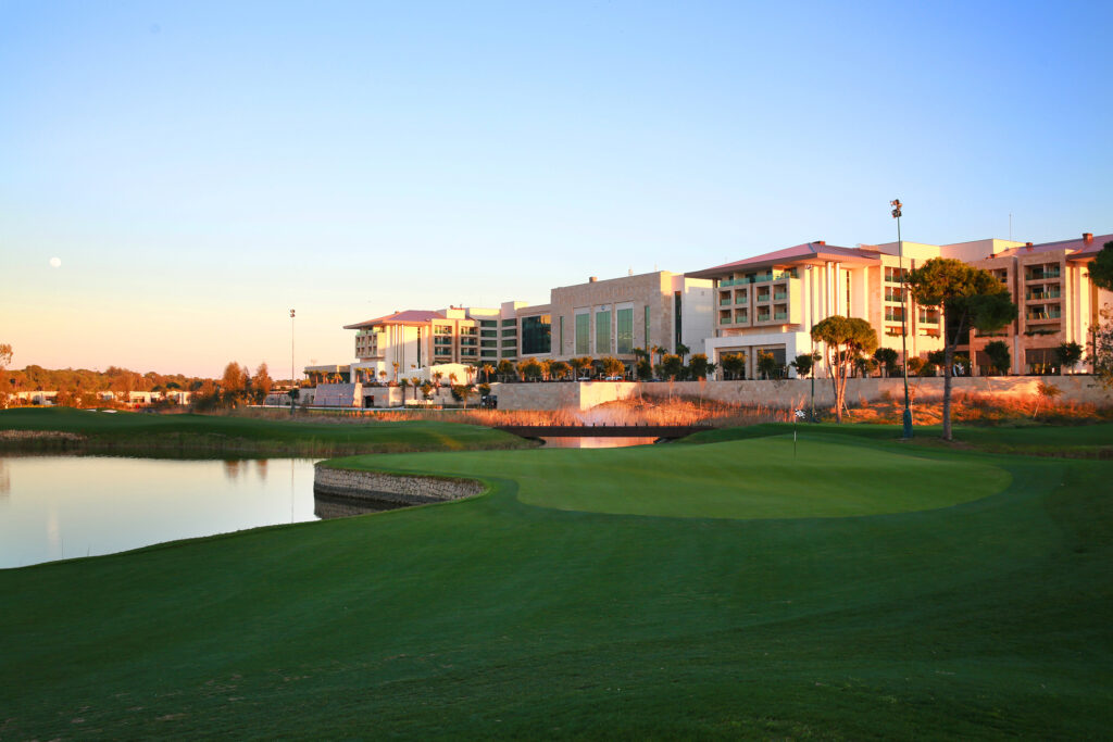 Hole with lake and building in background at Carya Golf Course