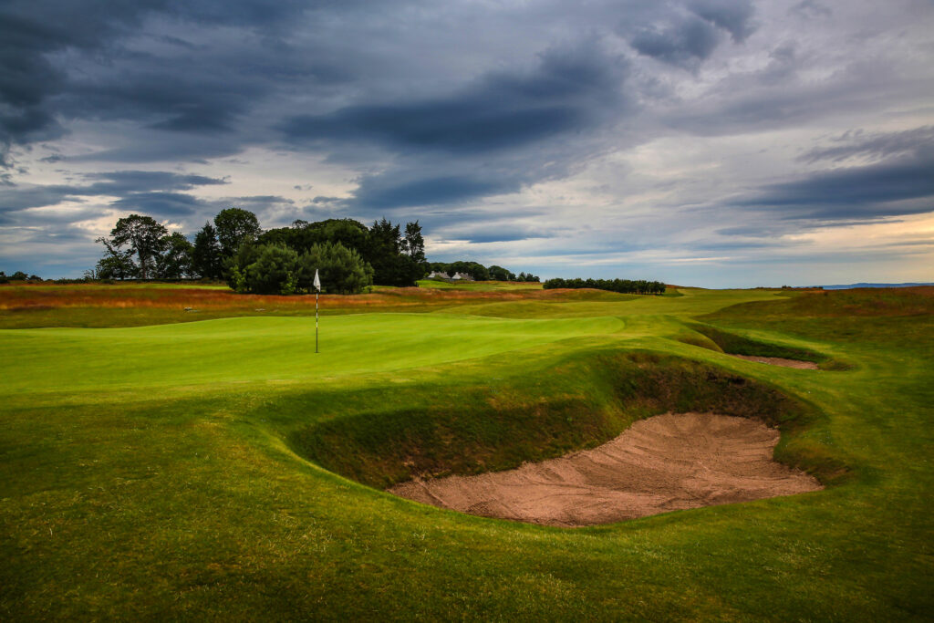 Hole with bunkers at Craigielaw Golf Club with trees in background