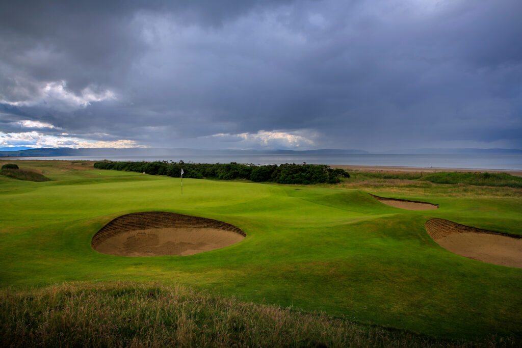 Hole with bunkers at Dumbarnie Links with ocean in background