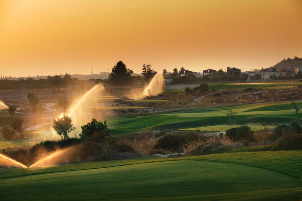 Sprinklers on over the fairway at Elea Golf Club at sunset