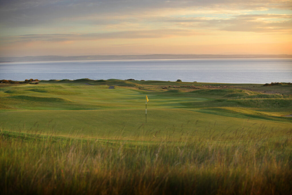 Hole with yellow flag at Fairmont St Andrews - Kittocks overlooking the ocean