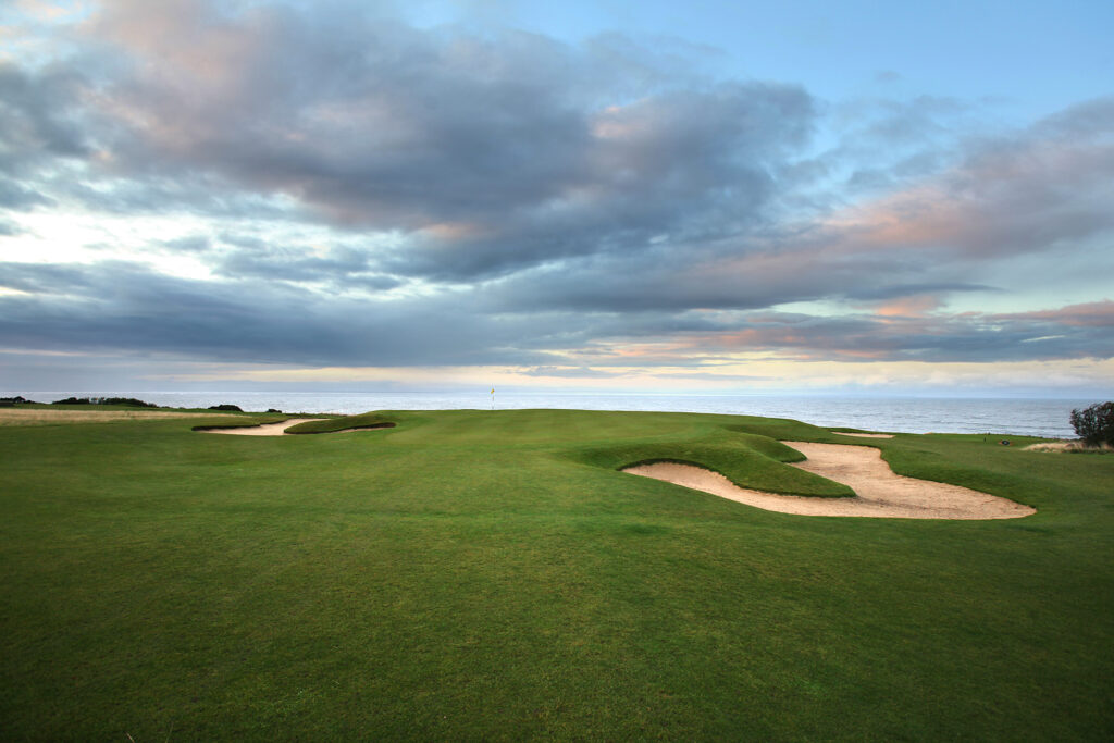 Hole with yellow flag and bunkers at Fairmont St Andrews - Torrance with ocean view