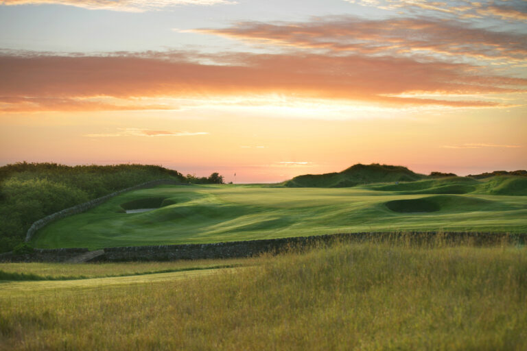 Fairway leading to hole with bunkers at Fairmont St Andrews - Torrance at sunset