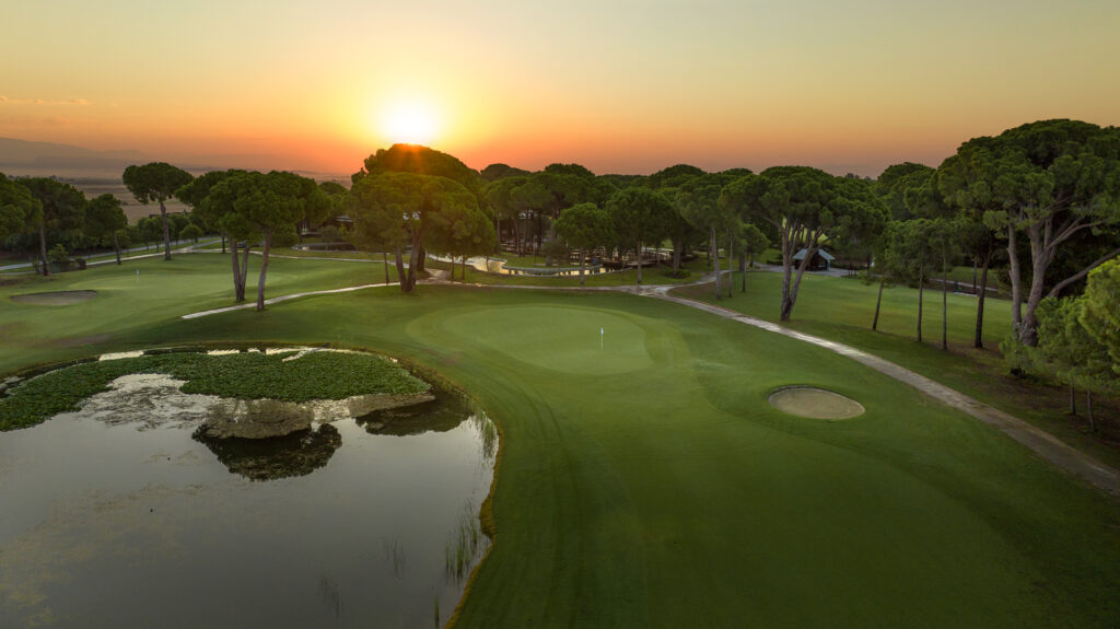 Aerial view of Gloria - New Golf Course with lake and trees around at sunset