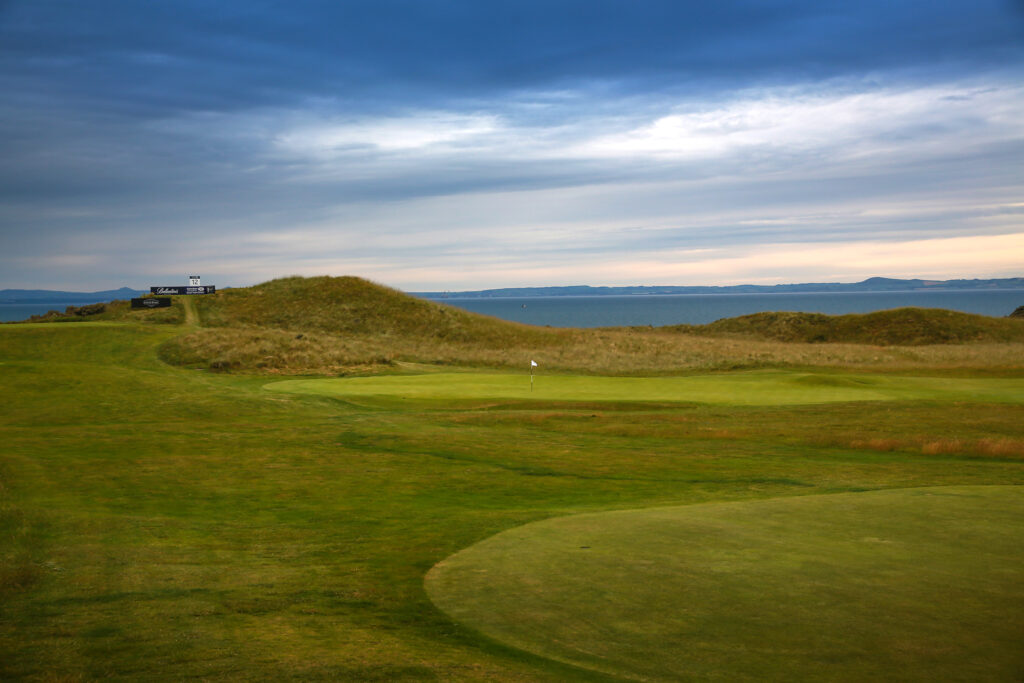 Hole with white flag with ocean in background at Gullane Golf Club - No. 1 Course