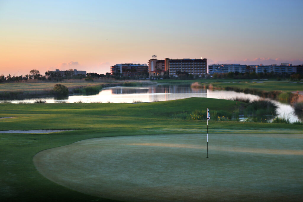 A hole with lake and building in background at Infinitum Lakes Course