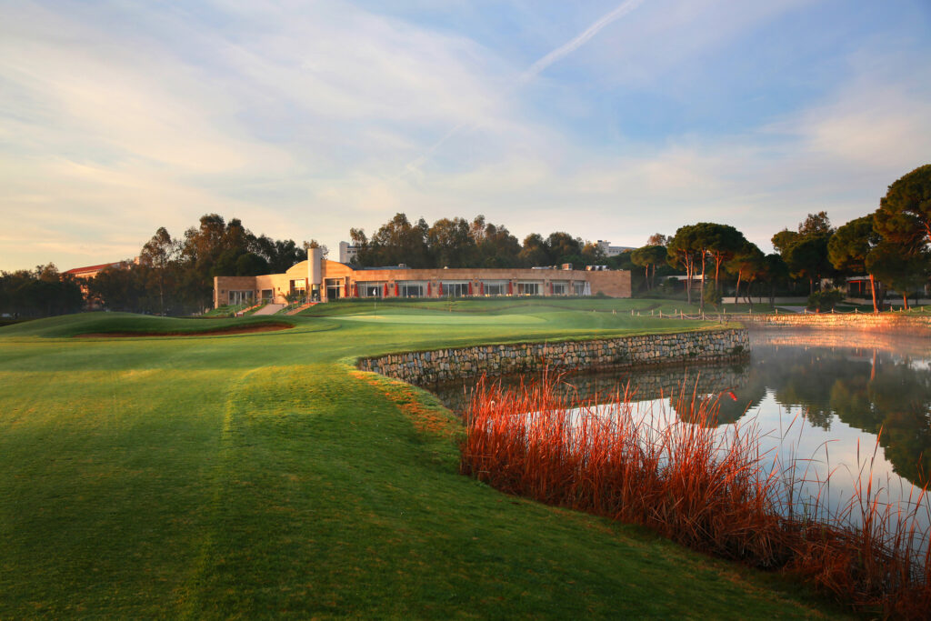 Lake on fairway with building and trees around at Kaya Palazzo Golf Club