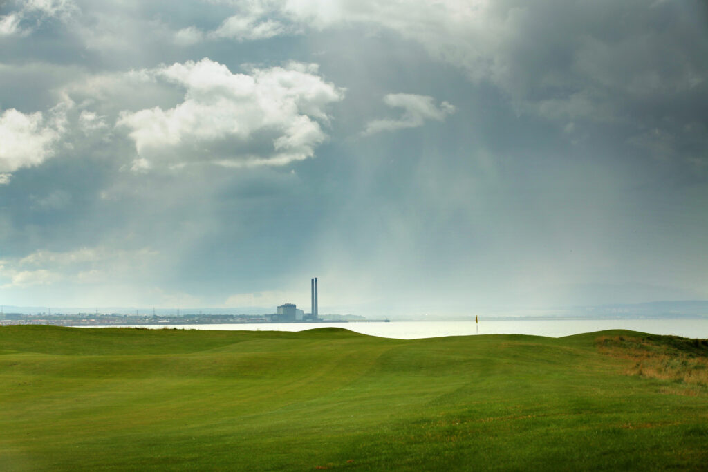 Fairway leading to hole with yellow flag at Kilspindie Golf Club