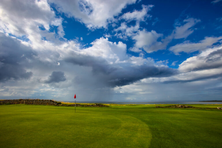 Hole with red flag at Fairway leading to hole with yellow flag at Kilspindie Golf Club