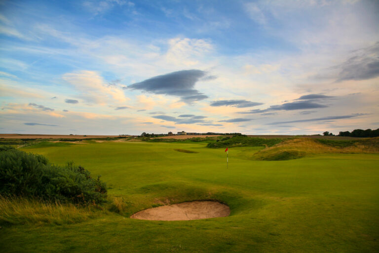 Hole with red flag and bunkers at Kingsbarns Golf Links