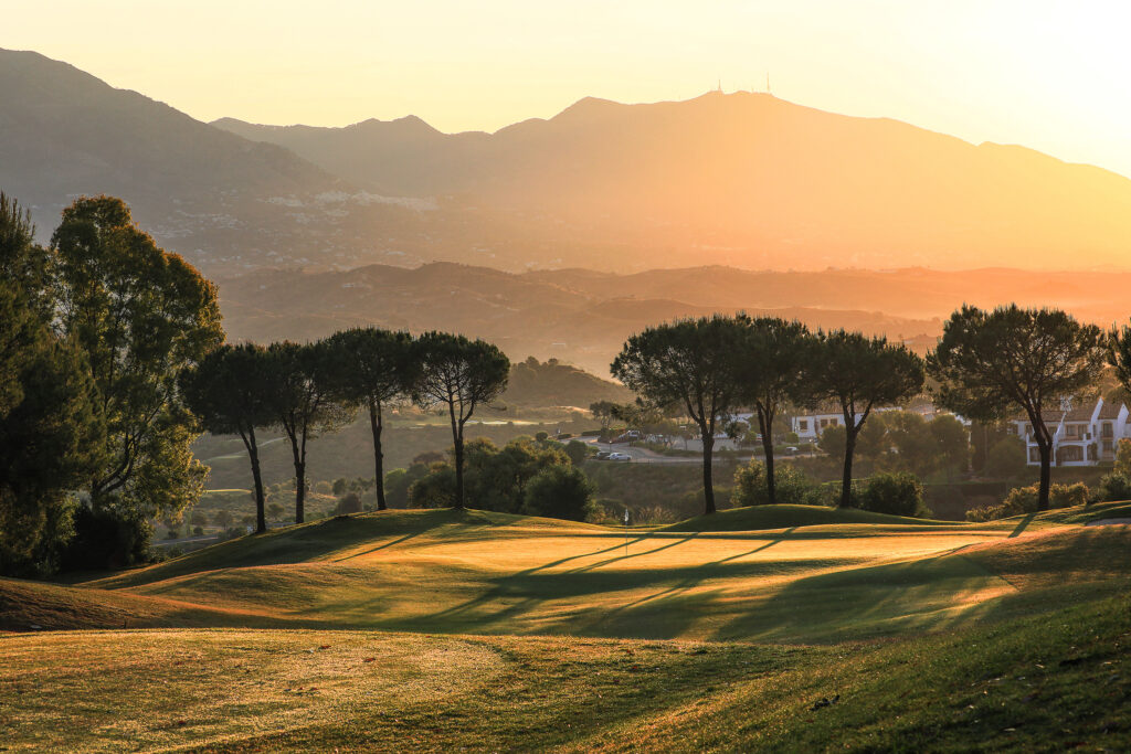 Hole with trees around and hills in background at La Cala - America Golf Course