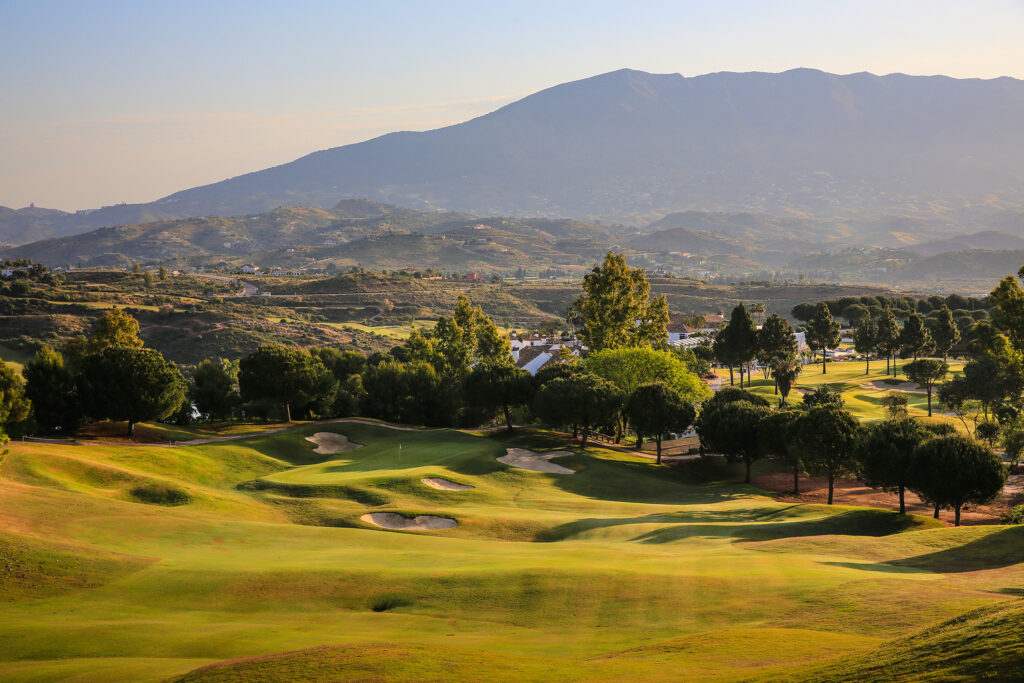 Fairway with bunkers and trees and hills in background at La Cala - America Golf Course