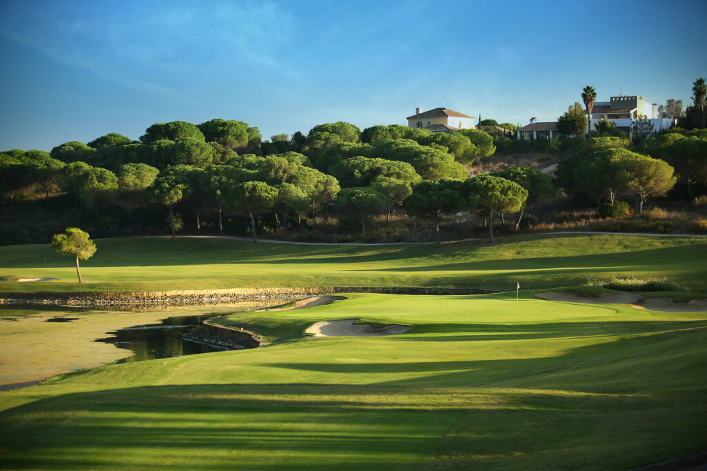 Fairway with lake and trees around at La Reserva de Sotogrande Golf Course