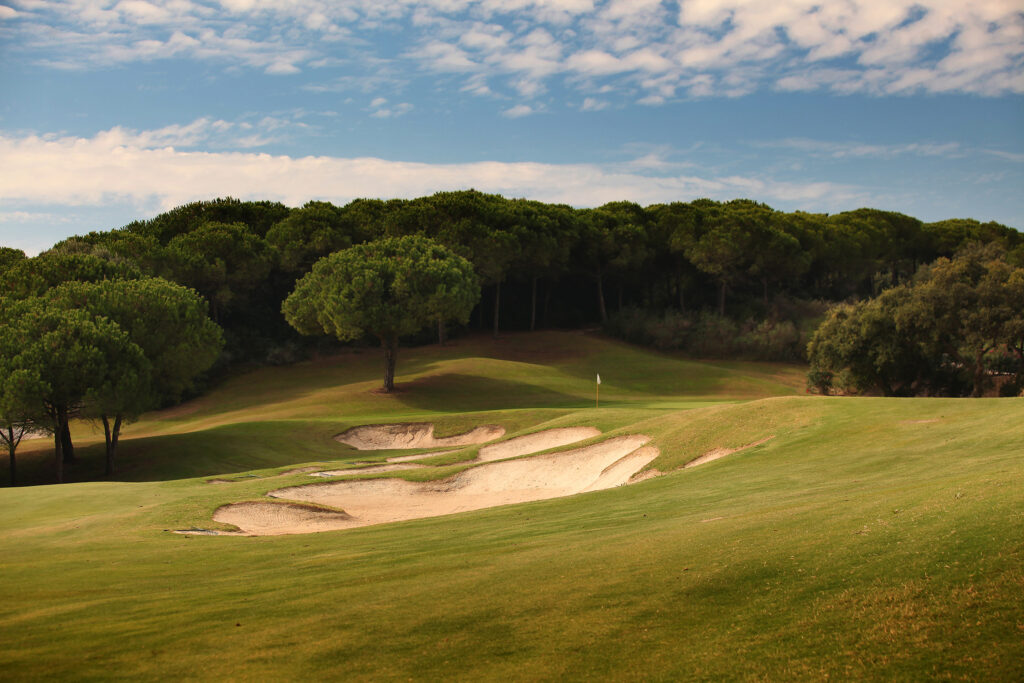 Bunkers on fairway with trees in background at La Reserva de Sotogrande Golf Course