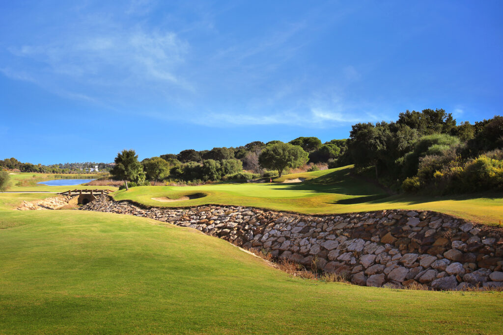 Fairway with stone wall and trees at La Reserva de Sotogrande Golf Course