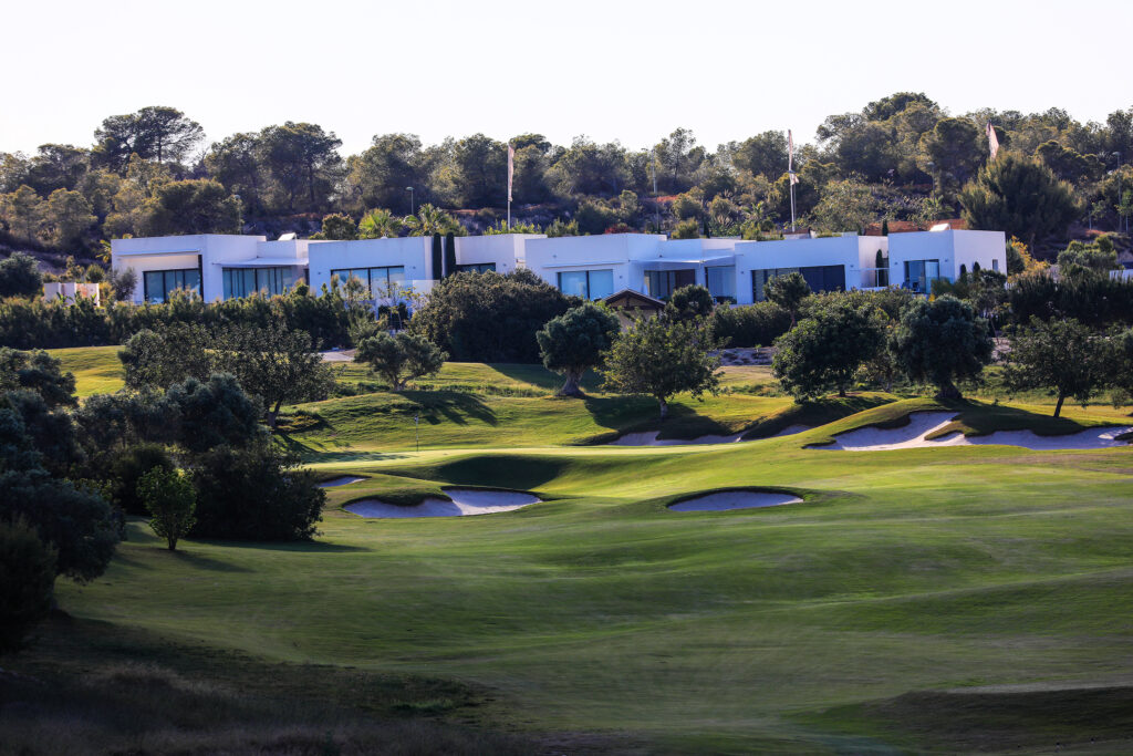 Fairway with bunkers at Las Colinas Golf & Country Club with buildings in background