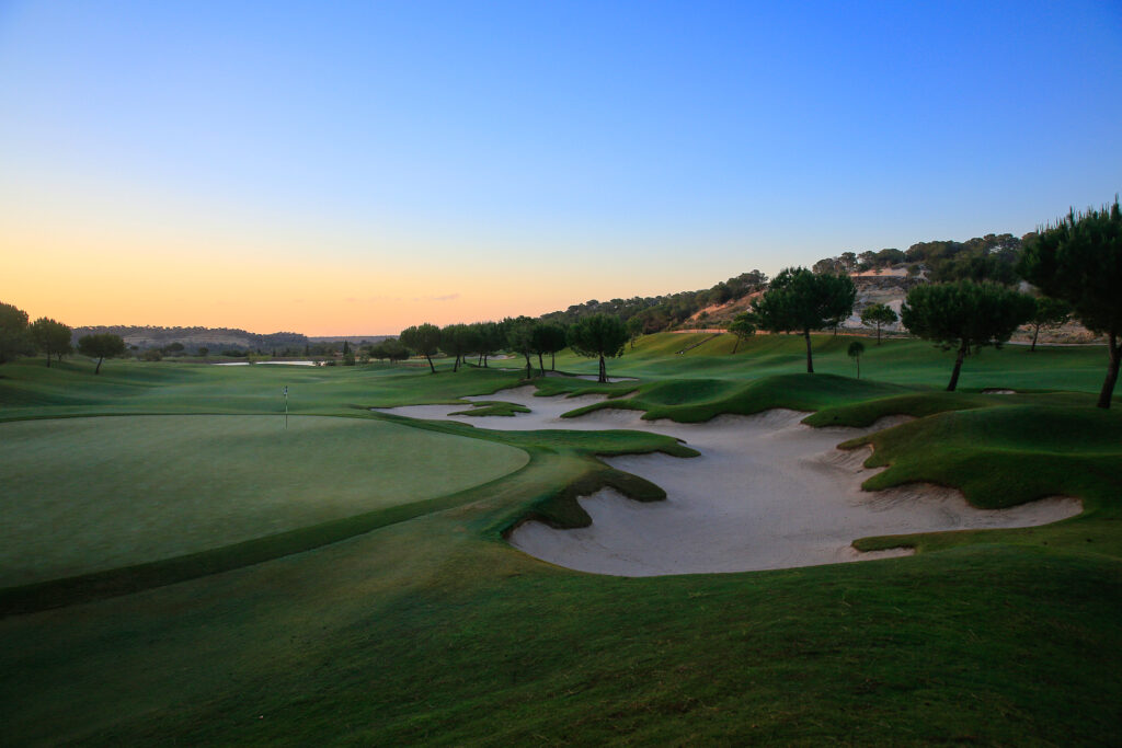 A hole with bunkers at Las Colinas Golf & Country Club at sunset