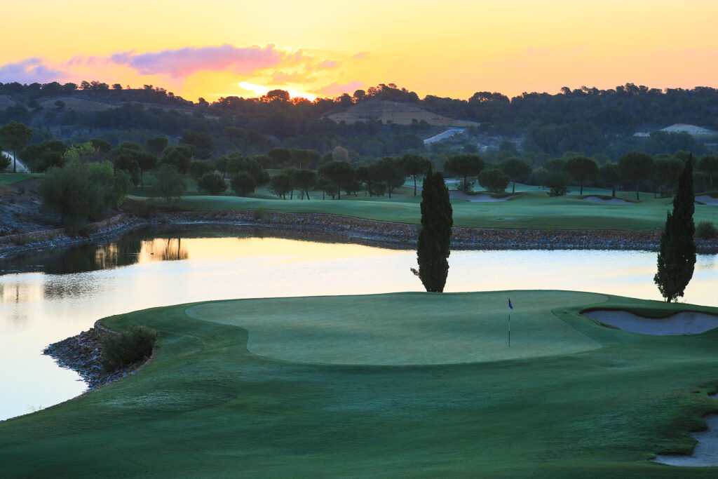 A hole with a lake in the background at Las Colinas Golf & Country Club