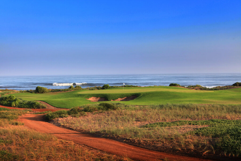 Hole with bunker at Mazagan Golf Course with ocean view