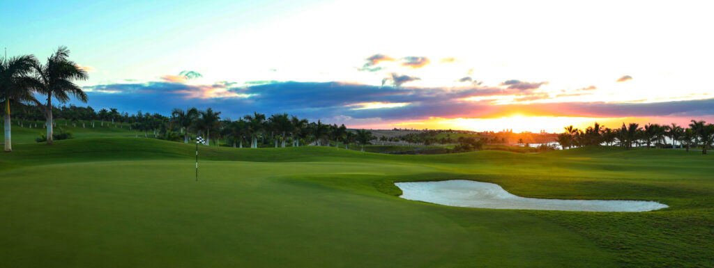 Hole with bunker and trees around at Meloneras Golf at sunset