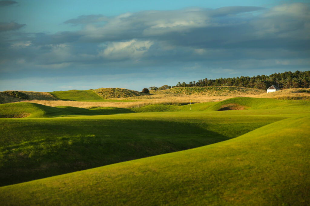 Fairway leading to hole with yellow flag at Muirfield