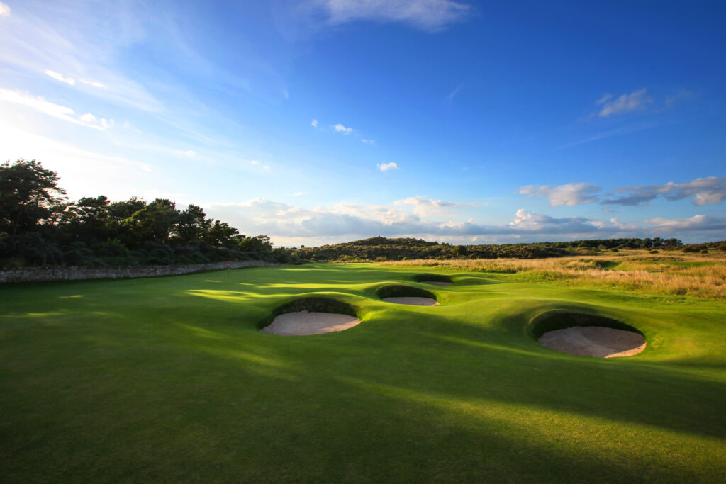 Hole with bunkers at Muirfield with trees in background