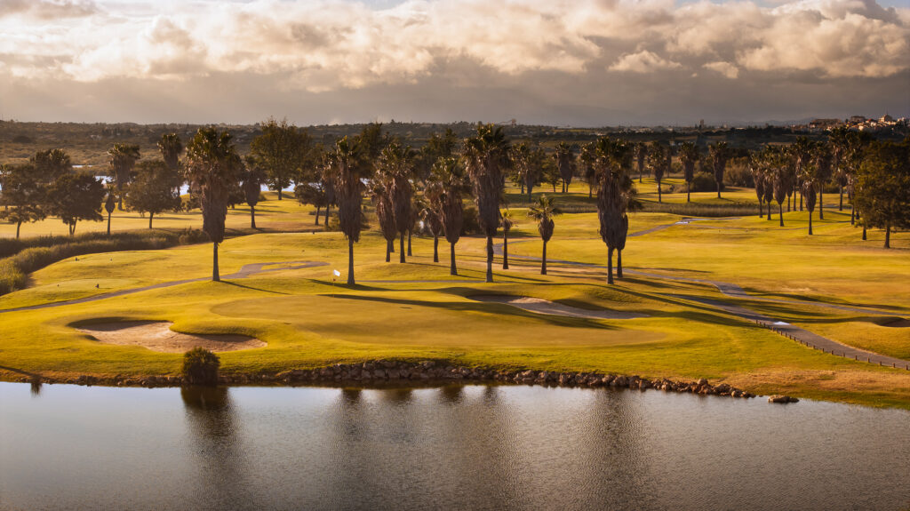 Palm trees on course with bunkers and water hazard at Salgados Golf Course