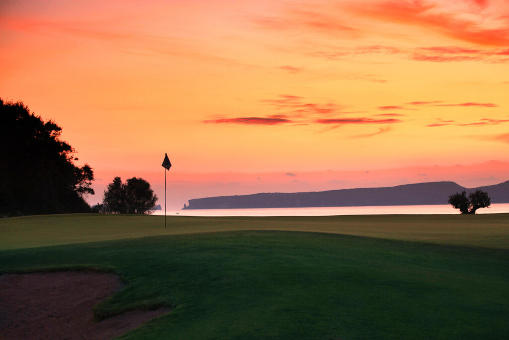 sunset over the Bay Course with a mountain backdrop