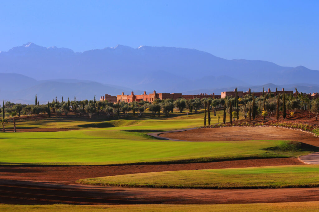 Bunkers on fairway at Palm Golf Ourika with trees and buildings in distance