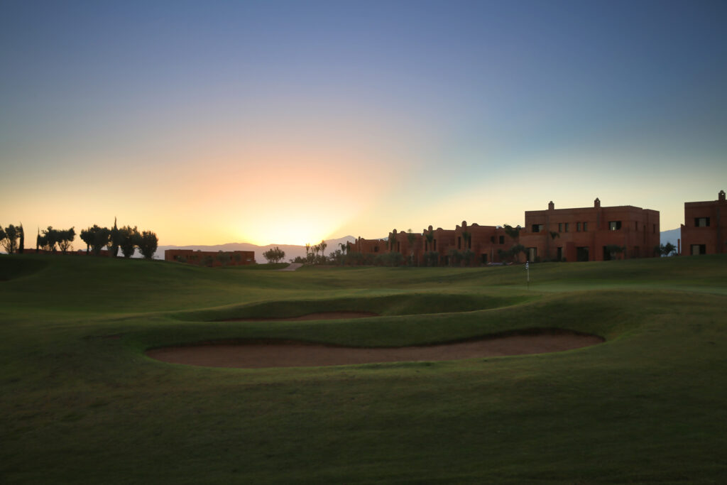 Bunkers on fairway at Palm Golf Ourika with buildings in distance