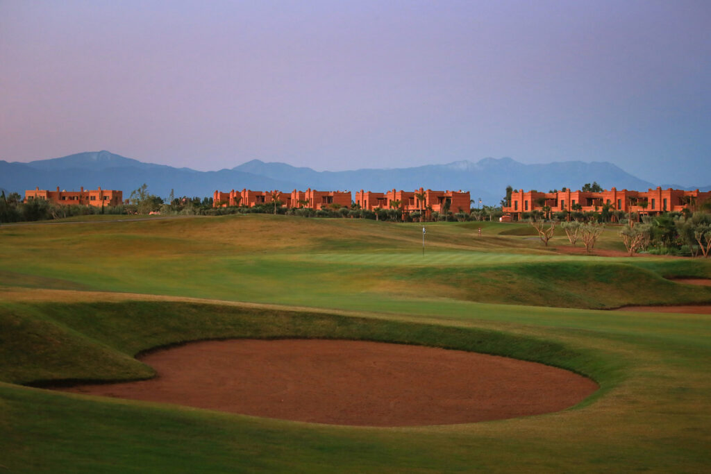 Bunkers on fairway at Palm Golf Ourika with buildings in distance