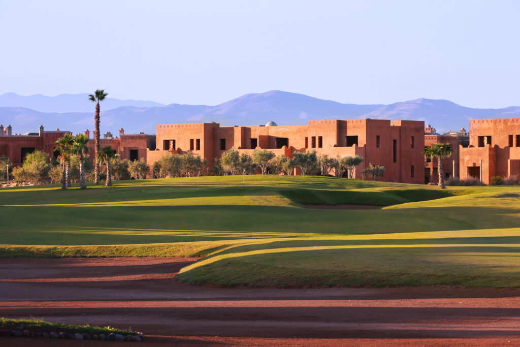 Bunkers on fairway at Palm Golf Ourika with buildings in background