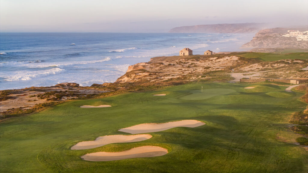 Aerial view of a hole with bunkers and beach view at Praia d'el Rey Golf Course