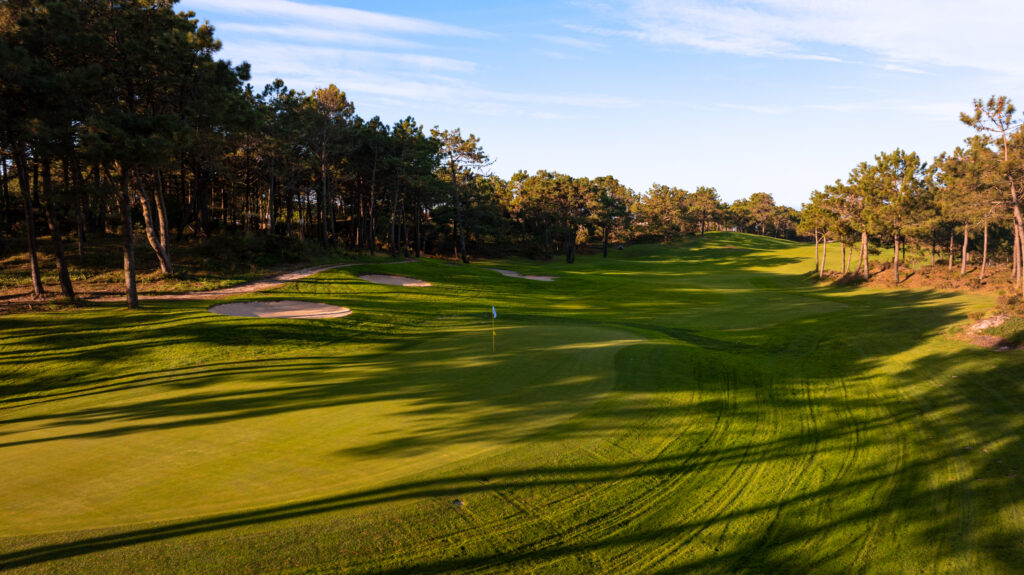 A hole with bunkers and trees around at Praia d'el Rey Golf Course