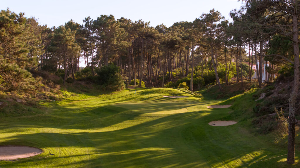 A hole with bunkers and trees around at Praia d'el Rey Golf Course